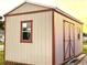 Tan and brown storage shed with double doors and window at 461 Clover Rd, Venice, FL 34293