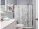 Clean bathroom featuring a white vanity, tiled shower, and floral shower curtain at 342 Wyler St, Port Charlotte, FL 33954