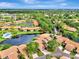 Aerial view of community with lake, pool, and lush landscaping at 3124 Windrush Bourne # 10, Sarasota, FL 34235
