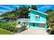 Exterior view of a charming teal house featuring a private pool and a spiral staircase at 1655 Memory Ln, Sarasota, FL 34231