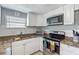 Updated kitchen with granite countertops, stainless steel appliances, and white cabinetry at 105 2Nd Se Ave, Ruskin, FL 33570