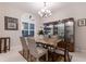 Dining room featuring marble table, display cabinet, chandelier, and window with shutters at 16211 Mulholland Rd, Parrish, FL 34219