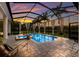 Sparkling pool with spa, curtains, an enclosure, and lounge chairs perfect for relaxing in a luxurious outdoor space at 16211 Mulholland Rd, Parrish, FL 34219