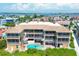 Overhead shot of a beachfront condo complex with private balconies, a swimming pool, and lush tropical landscaping at 1900 Gulf N Dr # 4, Bradenton Beach, FL 34217