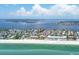 Breathtaking aerial view of the beachfront community, sparkling ocean, and bright blue sky with puffy clouds at 1900 Gulf N Dr # 4, Bradenton Beach, FL 34217