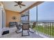 Relax on the screened balcony overlooking a beautiful beach with a dining table, ceiling fan, and seating at 1900 Gulf N Dr # 4, Bradenton Beach, FL 34217