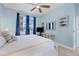 Light and airy bedroom with blue walls, a ceiling fan, and a desk by the window at 1900 Gulf N Dr # 4, Bradenton Beach, FL 34217