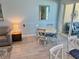 Cozy dining area with white table, four chairs, and access to the patio at 1900 Gulf N Dr # 4, Bradenton Beach, FL 34217