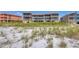 Beachfront view of a condo building featuring spacious balconies and tropical foliage at 1900 Gulf N Dr # 4, Bradenton Beach, FL 34217