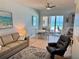 Cozy living room featuring a comfortable sofa and sliding glass doors to the beachfront balcony at 1900 Gulf N Dr # 4, Bradenton Beach, FL 34217