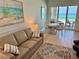 Cozy living room featuring a comfortable sofa and sliding glass doors to the beachfront balcony at 1900 Gulf N Dr # 4, Bradenton Beach, FL 34217