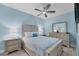 Relaxing main bedroom with light blue walls, ceiling fan, light colored wood furniture, and light tile floors at 1900 Gulf N Dr # 4, Bradenton Beach, FL 34217