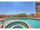 A tranquil pool and hot tub area is surrounded by a fence, lush greenery, and offers serene ocean views at 1900 Gulf N Dr # 4, Bradenton Beach, FL 34217