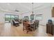 Open concept dining room with a rustic wooden table and views of the living room and kitchen at 5713 Cheech Gln, Lakewood Ranch, FL 34211
