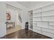 Home office with built-in shelving, hardwood floors, and view of stairs at 5713 Cheech Gln, Lakewood Ranch, FL 34211