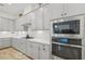 Modern kitchen with gray cabinets, stainless steel appliances and white quartz countertops at 5713 Cheech Gln, Lakewood Ranch, FL 34211