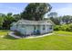 Light blue house with green lawn and two chairs at 105 2Nd Se Ave, Ruskin, FL 33570