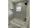 Renovated bathroom featuring marble tile and a bathtub at 20570 Tappan Zee Dr, Port Charlotte, FL 33952