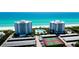 Aerial view of two beachfront buildings with tennis courts and parking at 1000 Longboat Club Road # 1103, Longboat Key, FL 34228