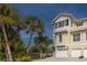 Three-story house with a white garage door and palm trees at 447 Canal Rd # 447, Sarasota, FL 34242