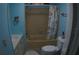 Full bathroom featuring a tub, toilet, and vanity with blue walls and neutral tiling at 6064 Shearwater Dr, Englewood, FL 34224
