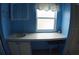 Blue bathroom featuring a long vanity and white cabinets under a window at 6064 Shearwater Dr, Englewood, FL 34224