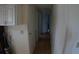 Long hallway with wood flooring, connecting various rooms with white walls and cabinet storage at 6064 Shearwater Dr, Englewood, FL 34224