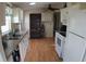 Practical kitchen featuring wooden floors, white appliances, and ample storage at 6064 Shearwater Dr, Englewood, FL 34224
