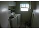 Functional laundry room with washer, dryer, and shelving for convenient storage at 6064 Shearwater Dr, Englewood, FL 34224