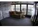 Enclosed sunroom with sofa and paneled glass, providing a cozy spot to enjoy natural light at 6064 Shearwater Dr, Englewood, FL 34224
