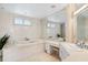 Bathroom features a large tub, tiled walls, vanity, and a well-lit mirror at 648 Beach Rd, Sarasota, FL 34242