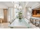 Elegant dining room features a glass table, designer lighting, and lots of natural light at 648 Beach Rd, Sarasota, FL 34242