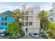 Three-story beach house showcasing unique architectural details, lush landscaping, and a paver driveway at 648 Beach Rd, Sarasota, FL 34242