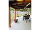 Back porch with a table, chairs, and landscaping creating a relaxing atmosphere to enjoy the outdoors at 906 Tropical Dr, Bradenton, FL 34208