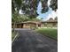 Charming ranch home with green exterior, carport and landscaping at 906 Tropical Dr, Bradenton, FL 34208