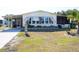 Single-wide mobile home with carport and landscaping at 6064 Shearwater Dr, Englewood, FL 34224