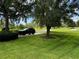 Spacious front yard with large trees and a black SUV at 22105 Deer Pointe Xing, Bradenton, FL 34202