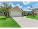 House exterior features a two-car garage and well-maintained lawn at 4925 70Th E St, Palmetto, FL 34221