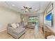 A spacious living room includes tray ceilings, ceiling fan, tile floor and sliding glass doors to the screened lanai at 12198 Longview Lake Cir, Bradenton, FL 34211