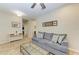 Neutral living room with tile floors, blue sofa and large picture window at 12198 Longview Lake Cir, Bradenton, FL 34211