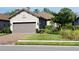 Single-story home with gray garage door, landscaping, and brick paver driveway at 14671 Derna Ter, Bradenton, FL 34211