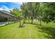 A large green backyard with a screened in pool and palm trees at 2204 Chipley Ave, North Port, FL 34286