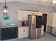 Bright kitchen featuring a stainless steel refrigerator, stylish cabinets, and charming decor accents at 2204 Chipley Ave, North Port, FL 34286