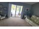 Carpeted living room featuring a white couch, chair, decorative artwork and sliding glass doors to the pool area at 2204 Chipley Ave, North Port, FL 34286