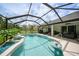 A beautiful screened in pool with clear blue water, seating and green backyard at 2204 Chipley Ave, North Port, FL 34286