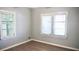 Bright bedroom featuring new wood-look laminate flooring, neutral gray walls and two windows at 5415 5Th N Ave, St Petersburg, FL 33710