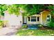 Charming single-story home with light yellow siding, an ADT security system, and a lush tree-lined front yard at 5415 5Th N Ave, St Petersburg, FL 33710