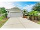 House exterior showcasing a two-car garage and lush landscaping at 12198 Longview Lake Cir, Bradenton, FL 34211