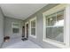 Covered front porch entry with gray exterior and landscaping at 12198 Longview Lake Cir, Bradenton, FL 34211