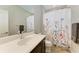 Bathroom with floral shower curtain and dark vanity at 12198 Longview Lake Cir, Bradenton, FL 34211